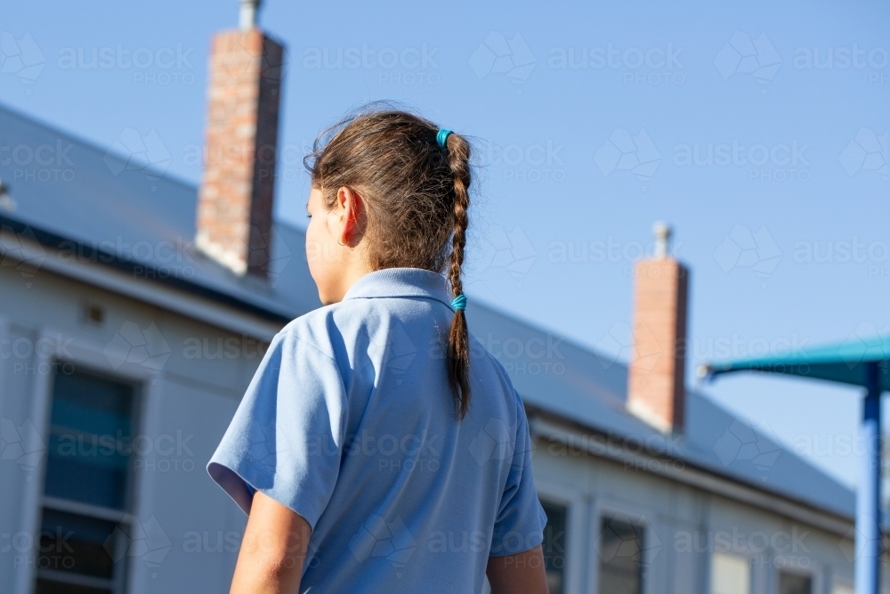 Schoolgirl with plait with back to camera - Australian Stock Image