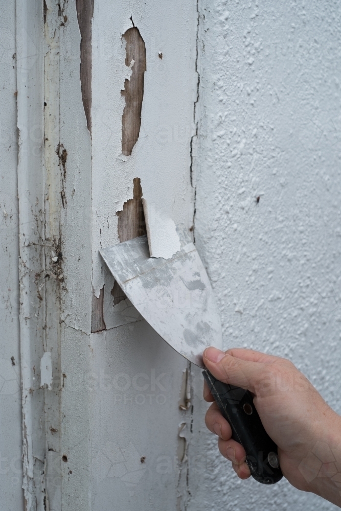 Image of Scraping old paint from window frame Austockphoto