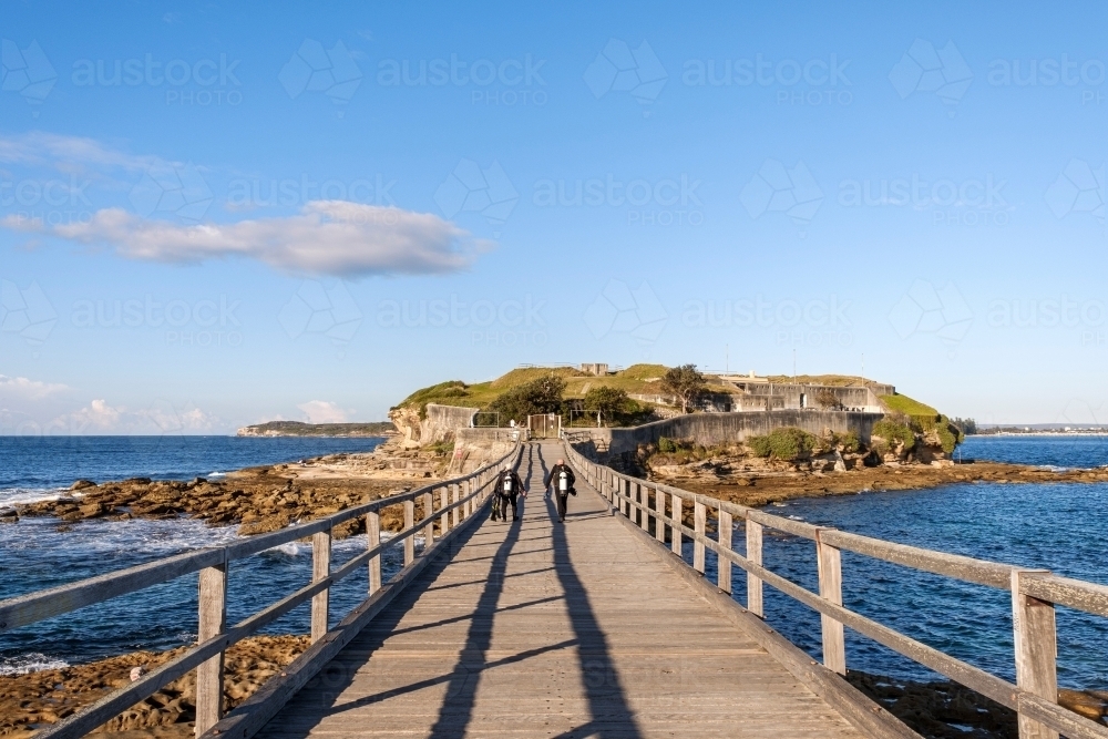 Scuba divers walking across bridge - Australian Stock Image