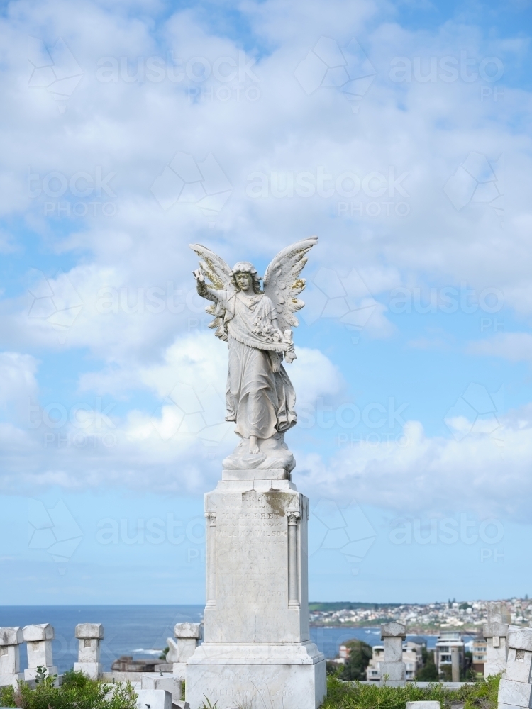 Sculpture of an angel wearing a long robe  under the blue skies - Australian Stock Image