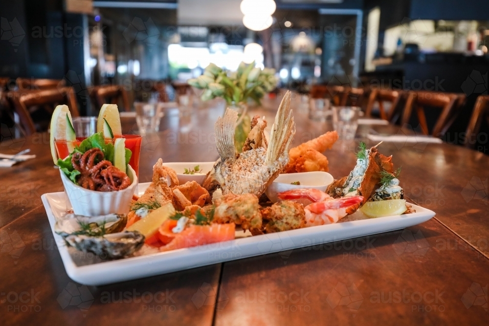 Image of Seafood platter in restaurant setting featuring squid, prawns ...