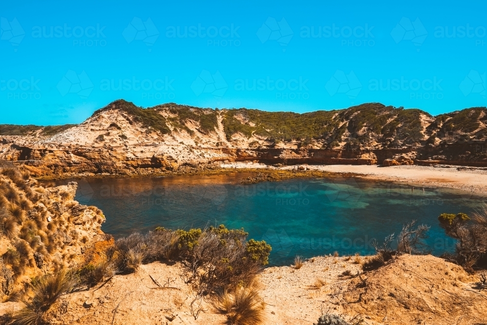 Secluded secret beach surrounded by rocky cliffs - Australian Stock Image