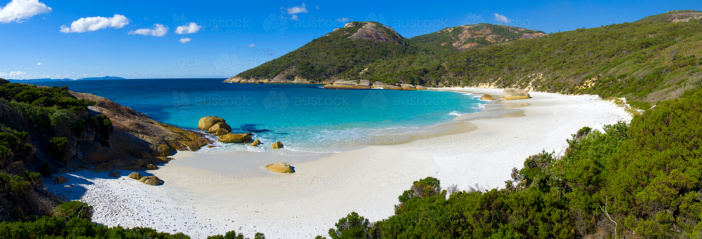 Secluded white sand beach with turquoise water and granite headlands on a sunny day - Australian Stock Image