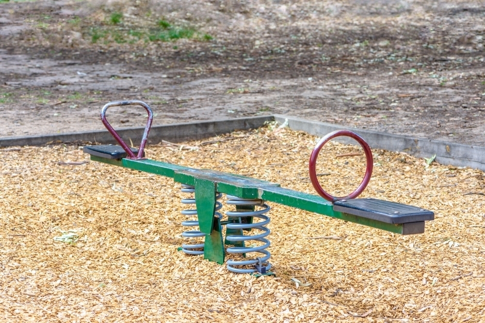 Seesaw in playground in the park no children - Australian Stock Image