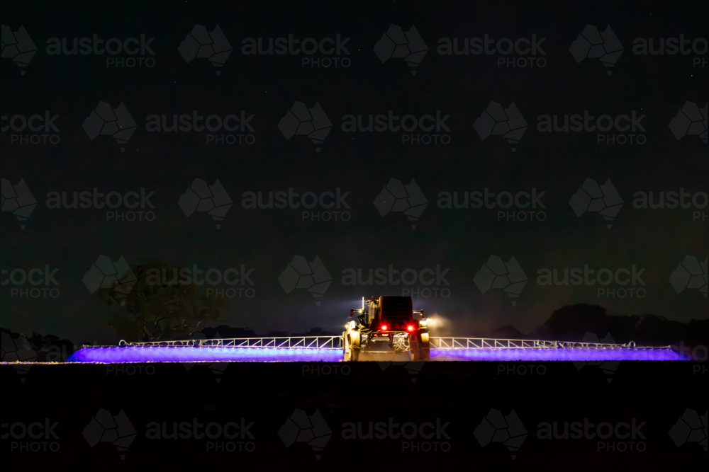 Self propelled boom sprayer spraying herbicide after planting canola - Australian Stock Image
