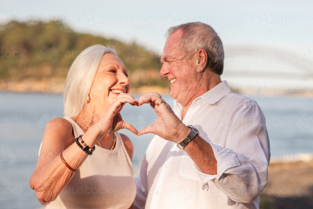 senior couple making heart hands together - Australian Stock Image