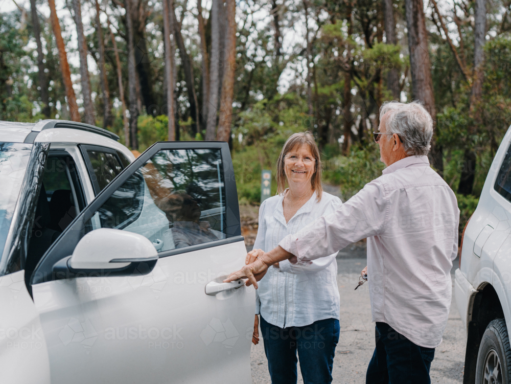 senior couple opening car door in Australian bushland - Australian Stock Image