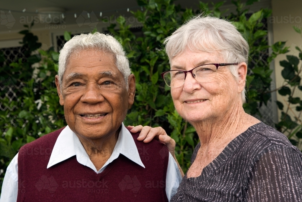 Senior couple standing outdoors smiling at the camera together - Australian Stock Image
