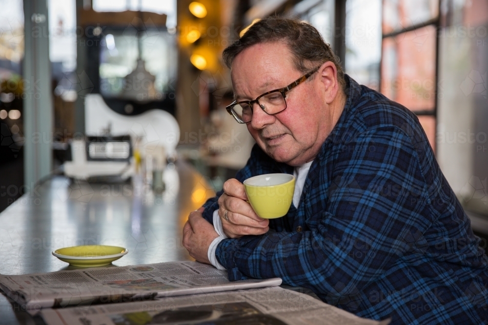 Senior Man Enjoying Coffee and Newspaper - Australian Stock Image