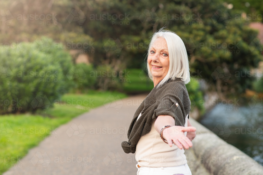senior woman holding her hand back to the camera - Australian Stock Image