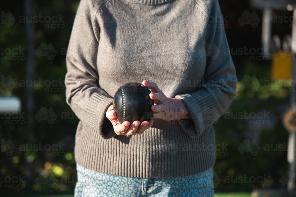 senior woman holding lawn bowls ball - Australian Stock Image