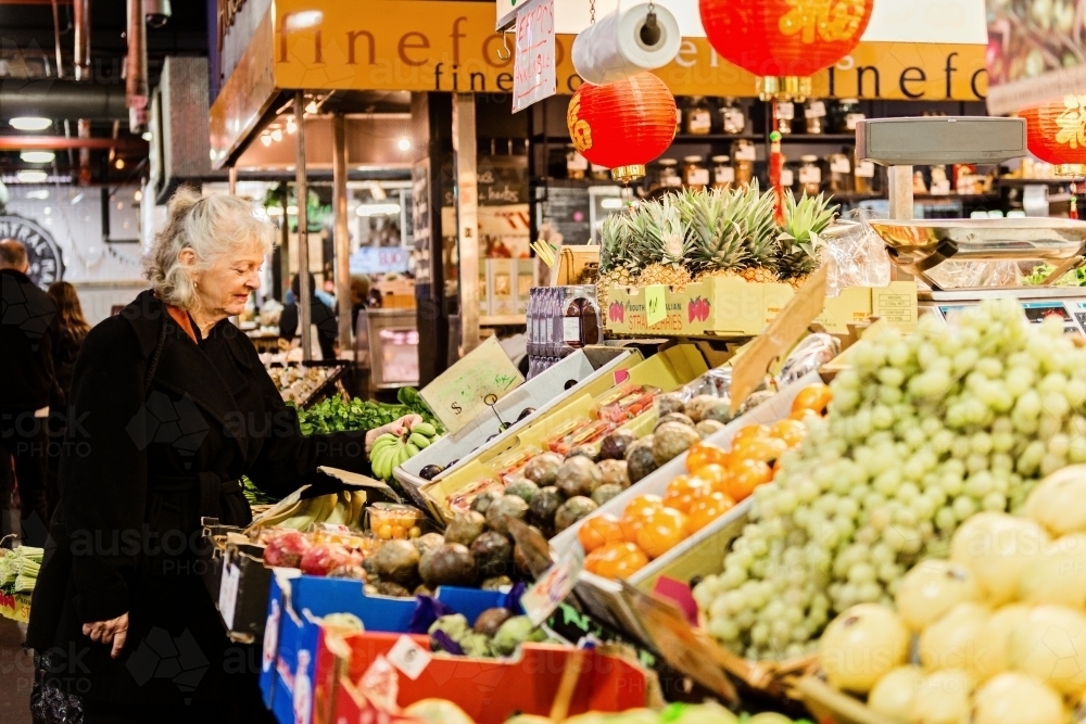 Senior woman shopping at fresh food market - Australian Stock Image