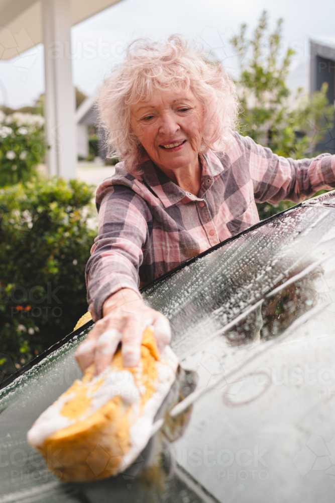 senior woman washing her car - Australian Stock Image