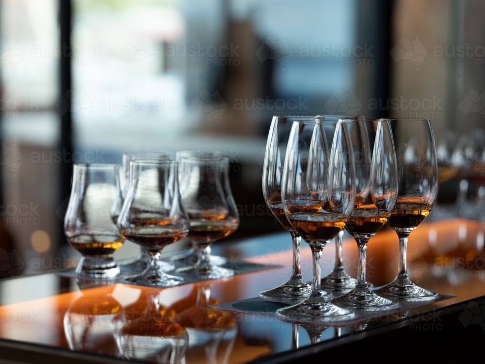 Series of glass wares filled with whisky for tasting - Australian Stock Image