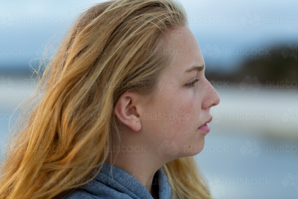 Serious girl with long blonde hair in profile - Australian Stock Image