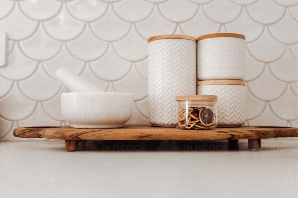 Serving platter with dried fruit, containers, and mortar with pestle - Australian Stock Image