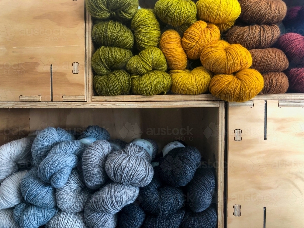 Sets of colourful skein yarn stacked in box shelves. - Australian Stock Image