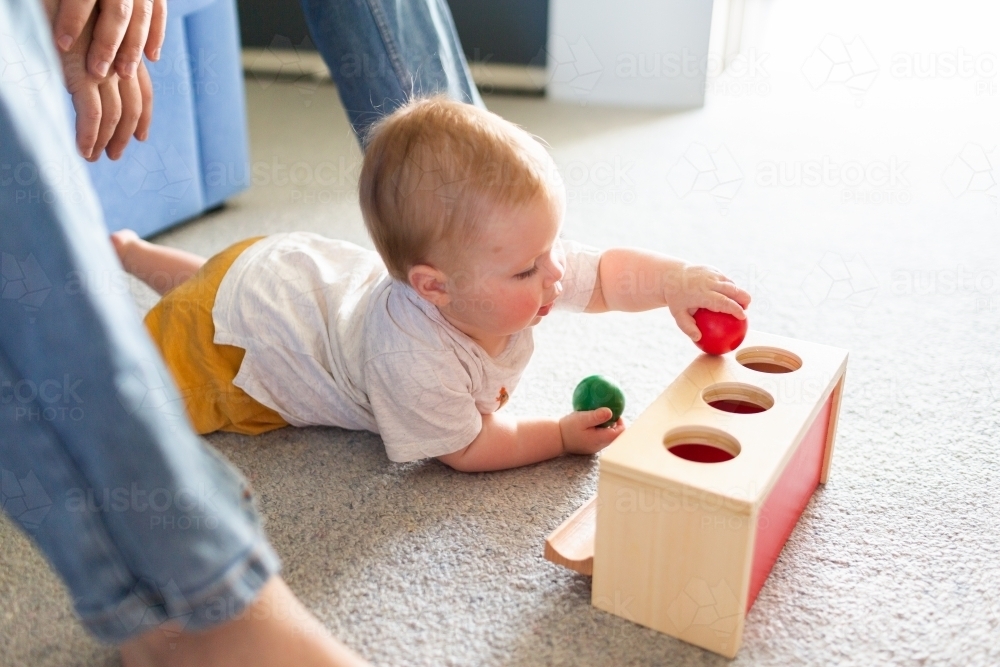 Image of Seven month old baby playing with object permanence ball drop