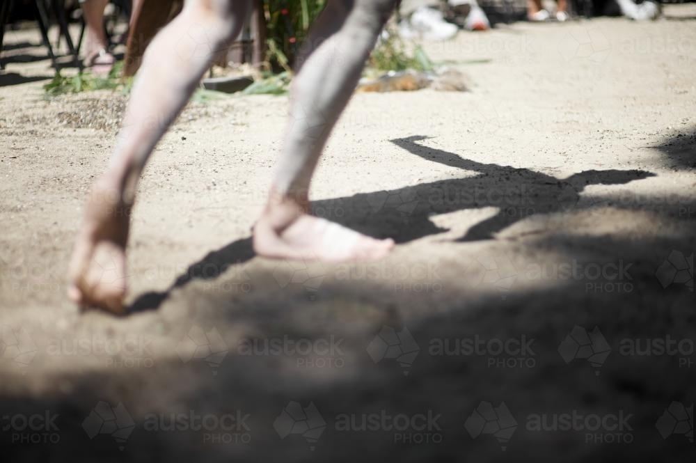Shadow and Legs of an Aboriginal Dancer - Australian Stock Image