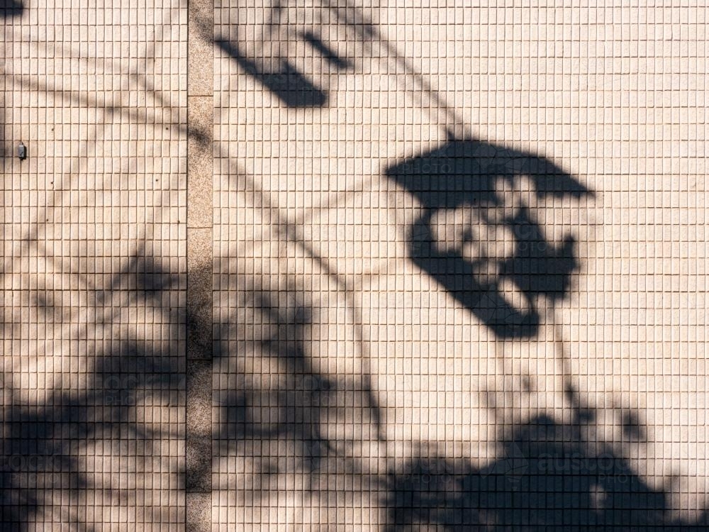 Shadow of people in a ferris wheel on a building wall - Australian Stock Image