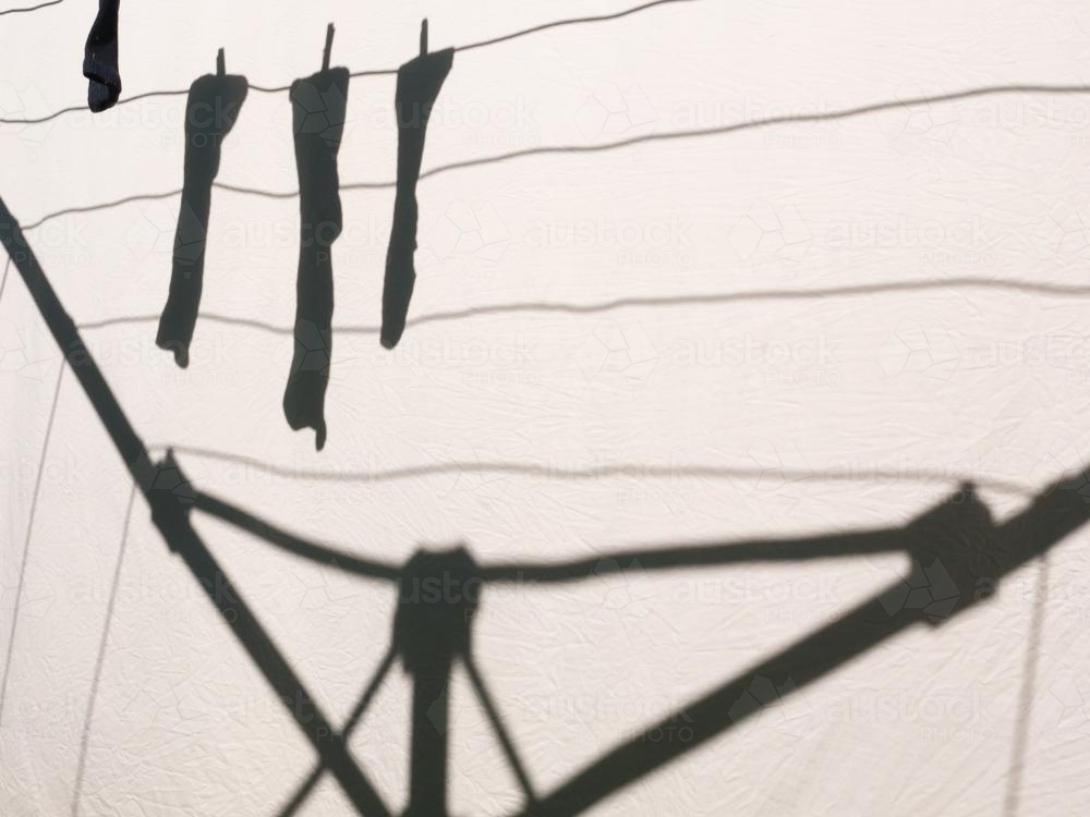 Shadow on a sheet of socks hanging on a clothes line - Australian Stock Image