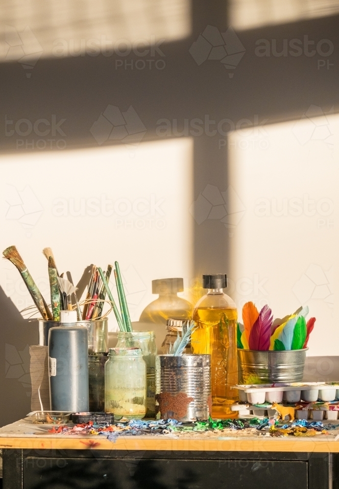 Shadows and light in an art studio with painters brushes and paint palette - Australian Stock Image