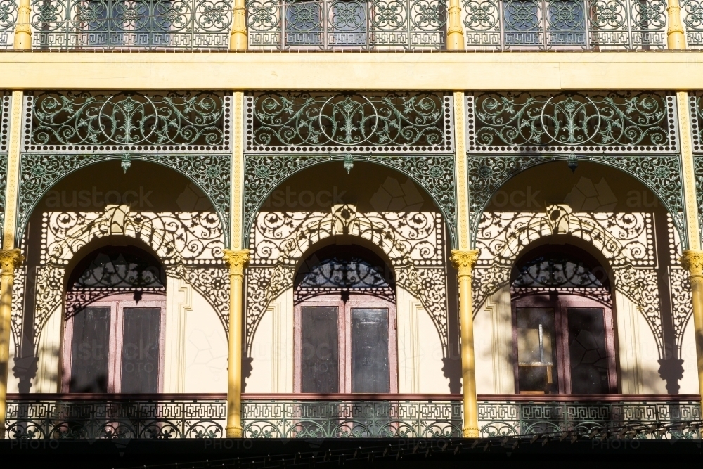 Shadows from wrought iron arches cast onto the facade of an historic building - Australian Stock Image