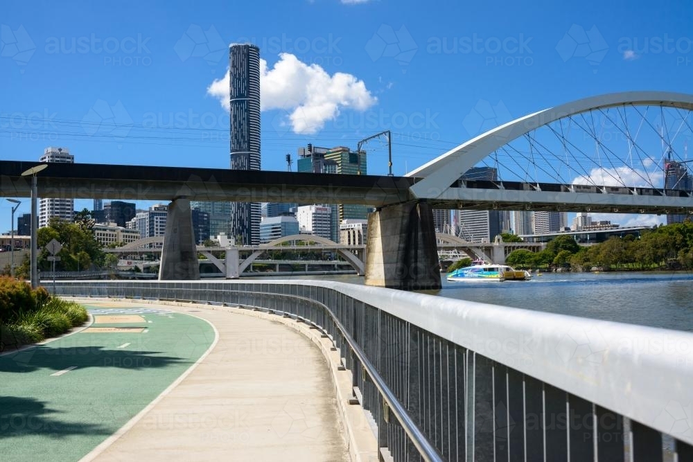 Shared pedestrian and bikeway beside Brisbane River with city , bridges and ferry - Australian Stock Image