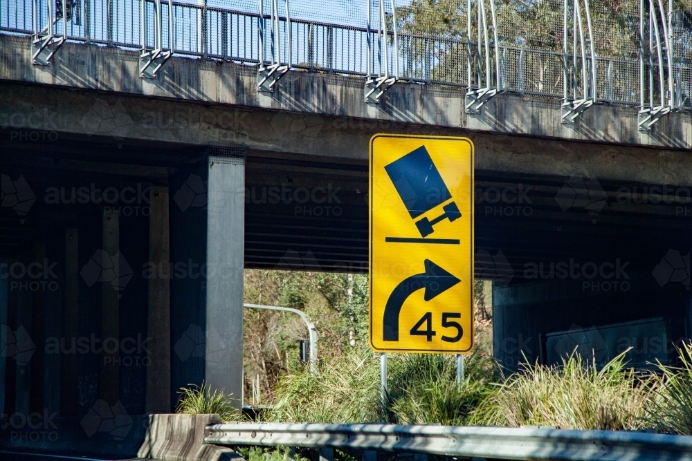 Sharp bend tilting truck sign with recommended speed - Australian Stock Image