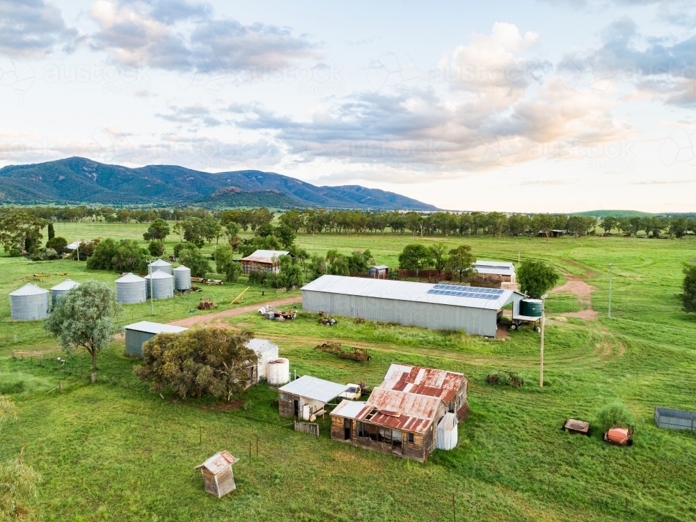 Sheds and old buildings on farm in green grass and paddocks - Australian Stock Image