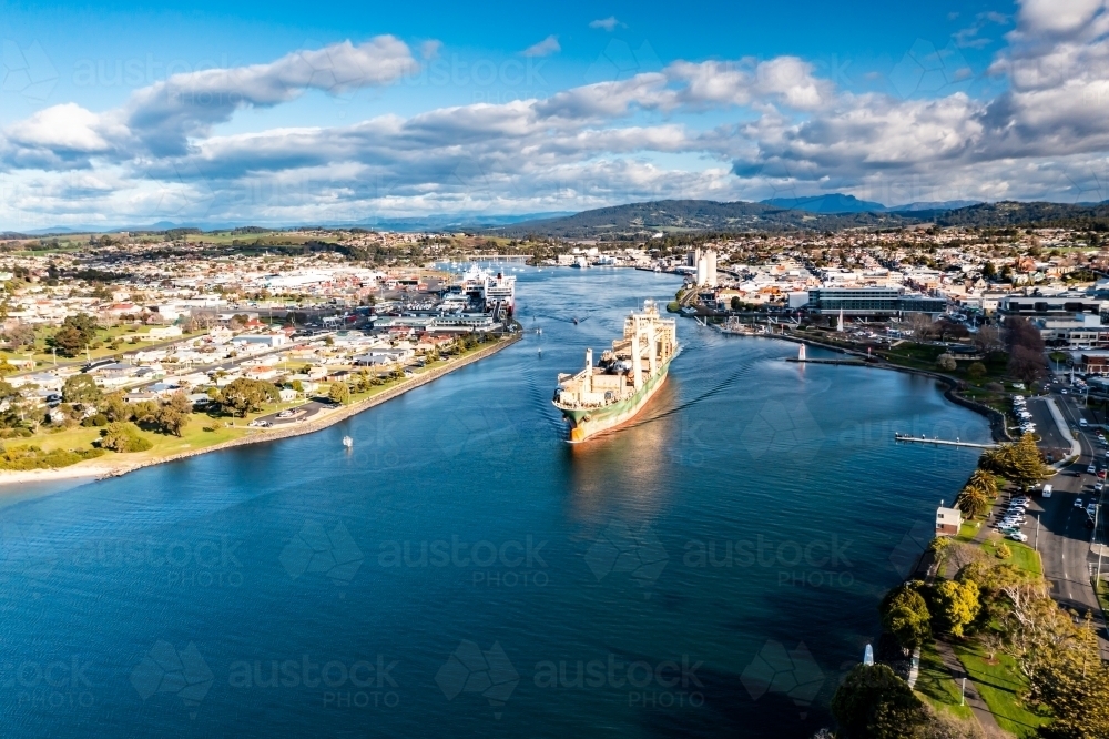 Ship departing port with scrapped tugboats on board - Australian Stock Image