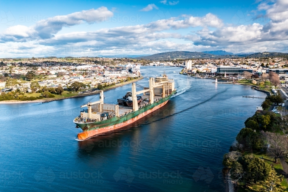 Ship leaving port with scrapped tug boats on board - Australian Stock Image