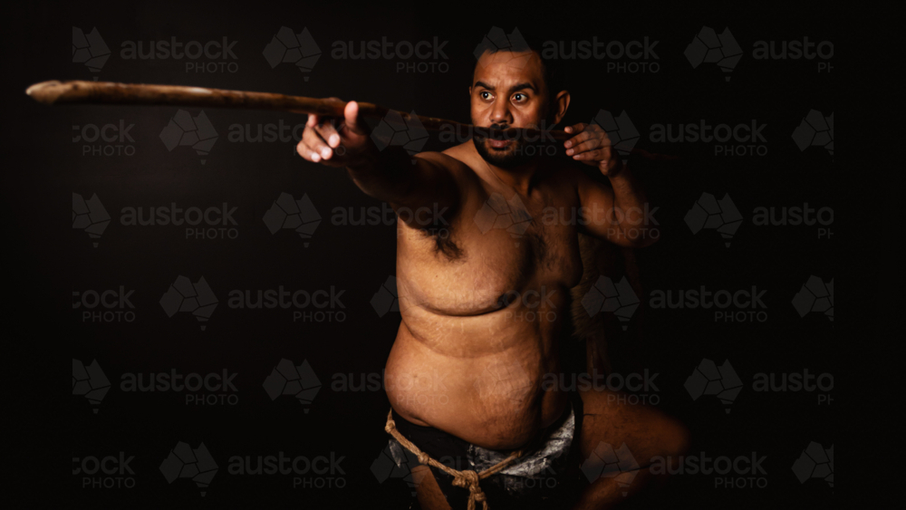 Shirtless aboriginal man holding a wooden spear - Australian Stock Image