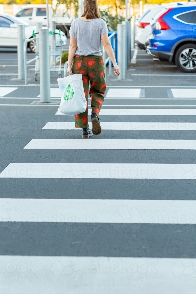 shopper walking across crosswalk at shopping centre carpark - Australian Stock Image