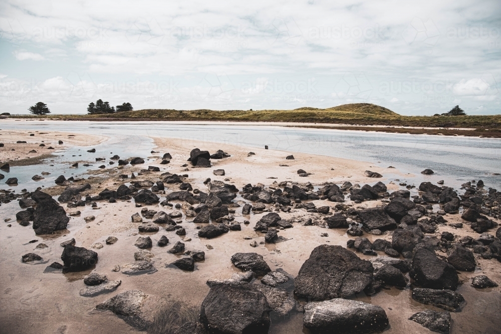 shoreline rocks near coastal river - Australian Stock Image