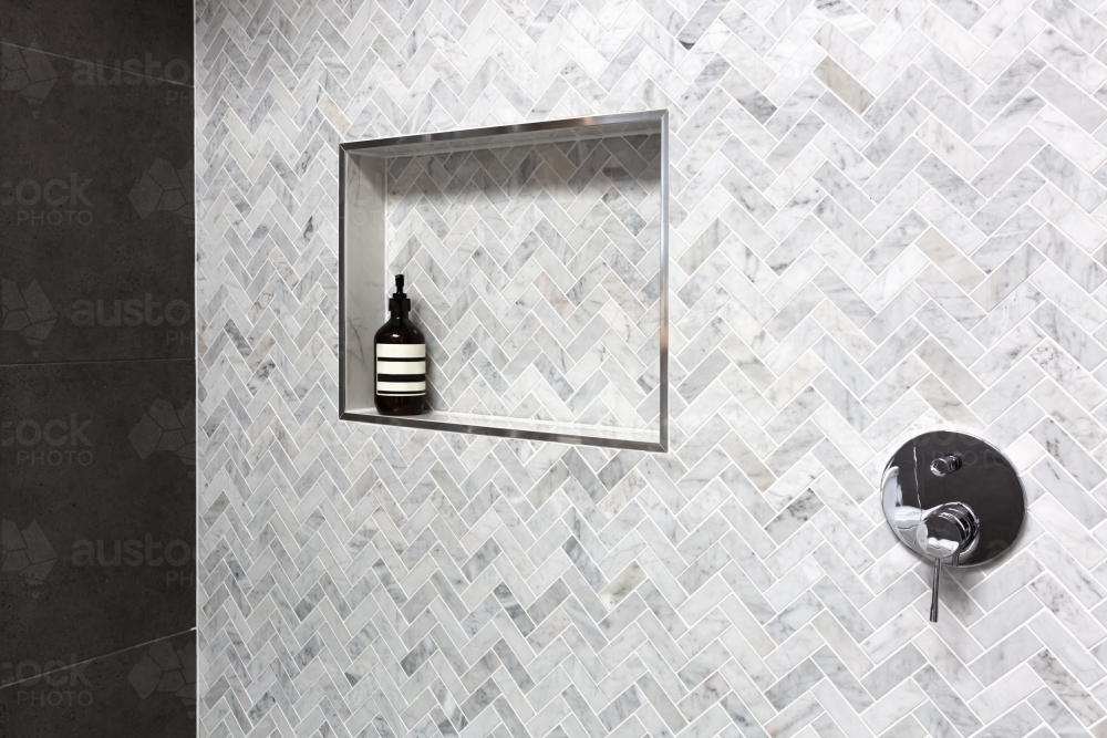 Show shelf detail in wall of herringbone marble tiles - Australian Stock Image