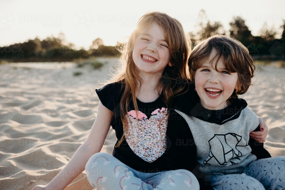 siblings laughing together - Australian Stock Image