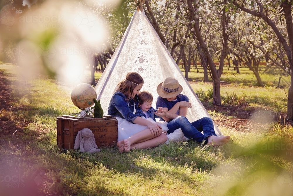 Siblings Sharing in a Lace Teepee - Australian Stock Image