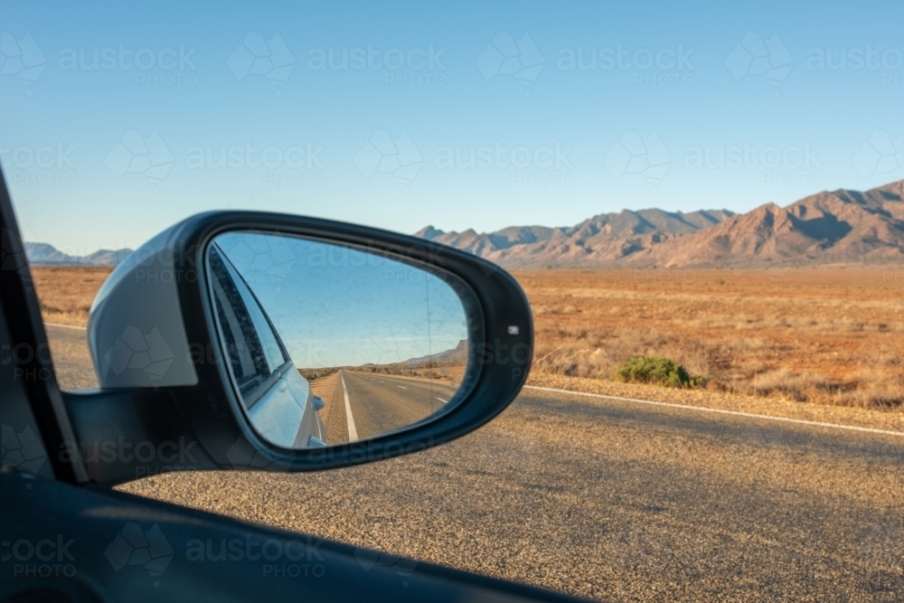 Side mirror of car showing road through Flinders Ranges, SA - Australian Stock Image