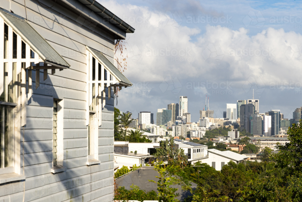 Side of a weatherboard Queenslander style home with a view towards the Brisbane city skyline - Australian Stock Image