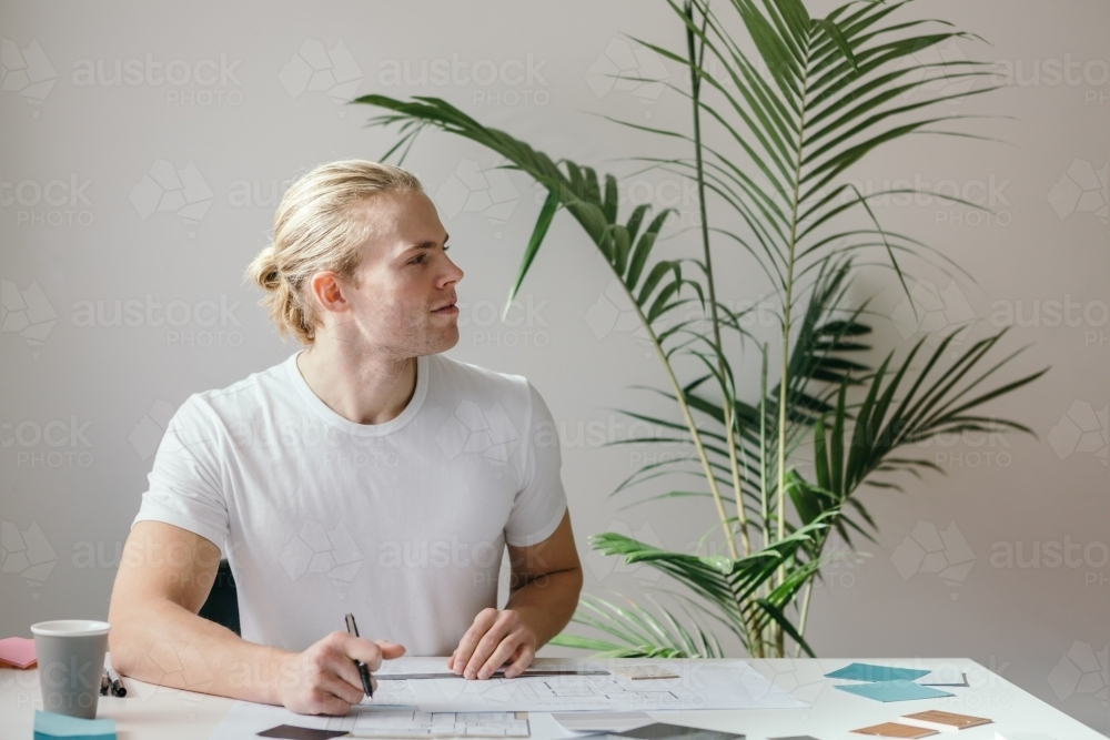 Side profile of a man sitting behind the desk - Australian Stock Image