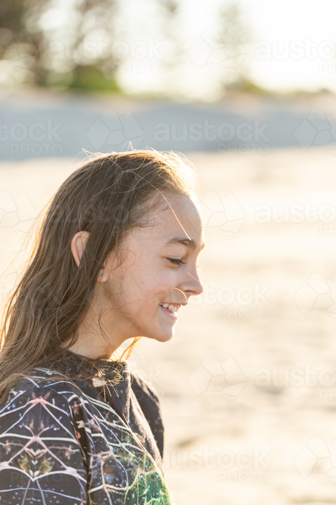 Side profile of Torres Strait Islander boy in sunshine at beach on windy day - Australian Stock Image