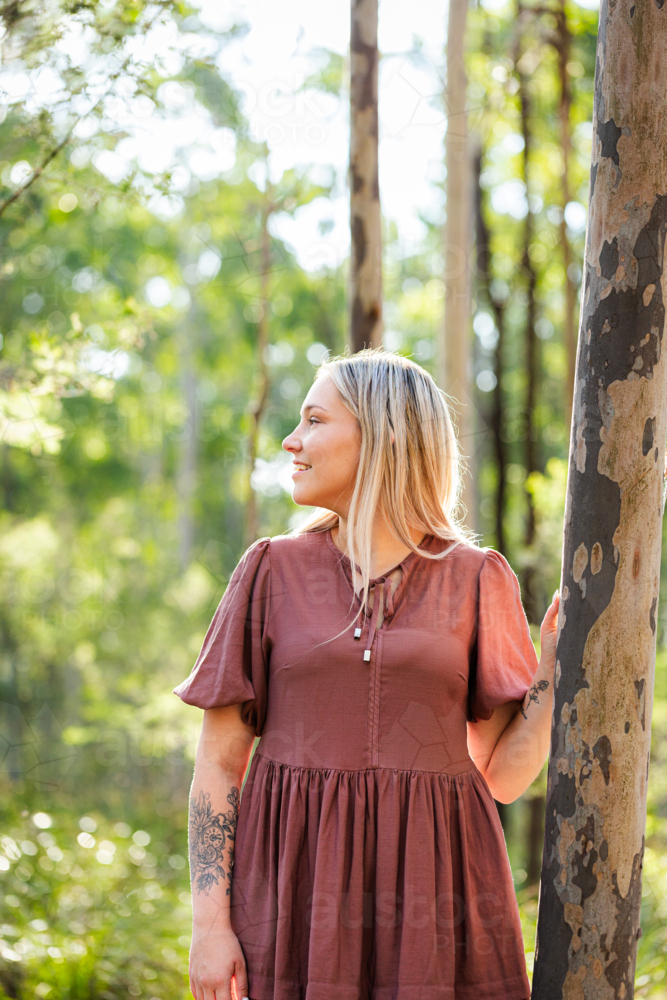 Side profile portrait of First Nations Australian woman standing in natural bushland - Australian Stock Image