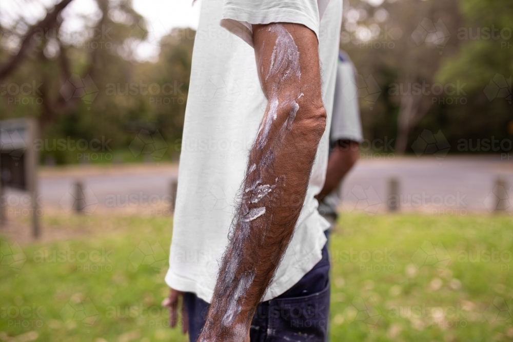 Side view of aboriginal man's arm with traditional white paint - Australian Stock Image