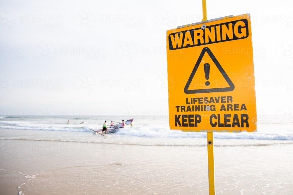 Image of sign lifesavers training and a surfboat in the background ...
