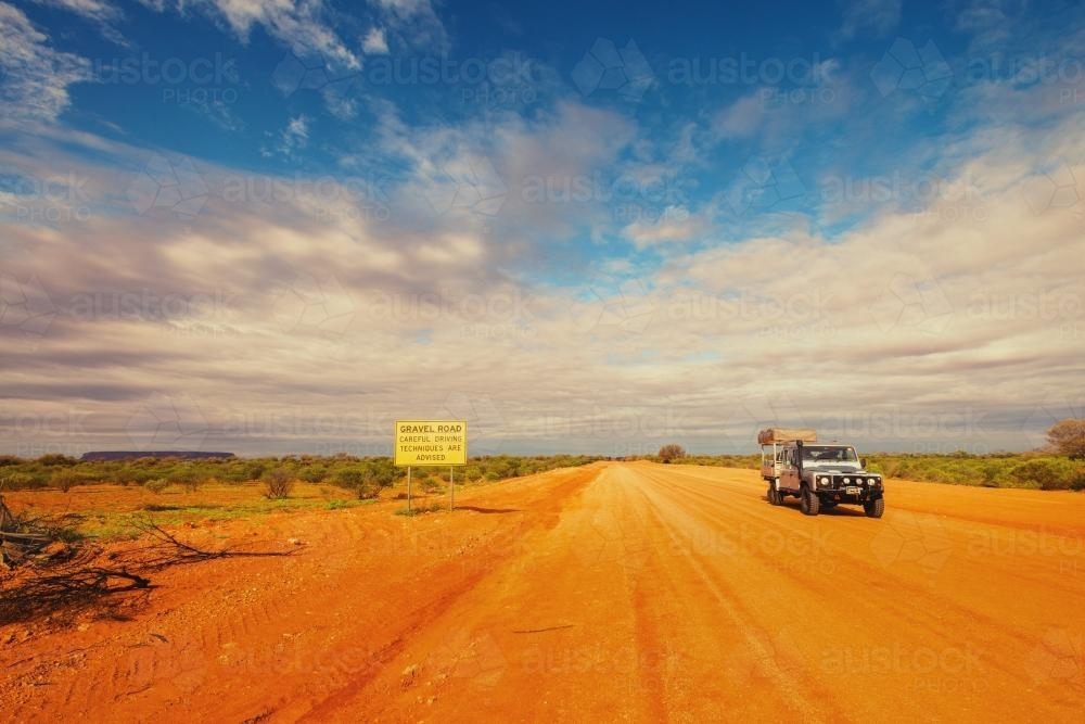Sign warning of loose gravel road in outback landscape of Northern Territory - Australian Stock Image