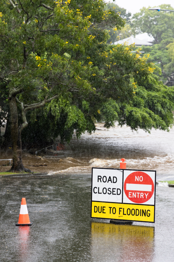 Signage across a flooded suburban road to stop traffic proceeding during a major rain event - Australian Stock Image