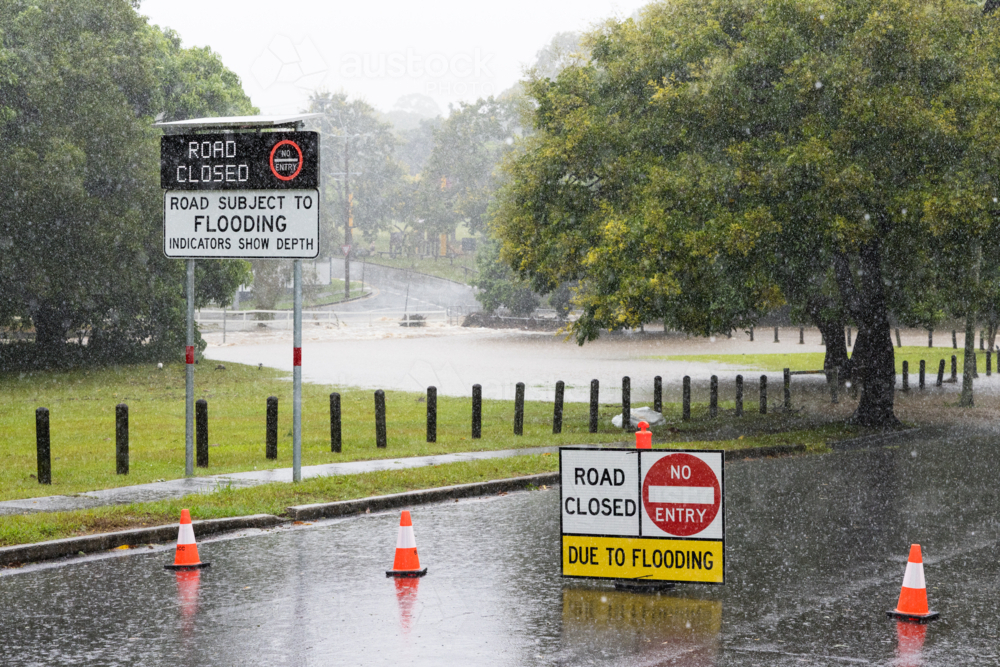 Signage on a road showing it is closed due to flooding in suburban Brisbane - Australian Stock Image