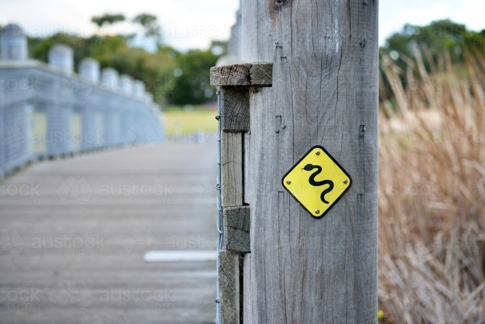 Signpost in bushland alerting people to the presence of snakes - Australian Stock Image