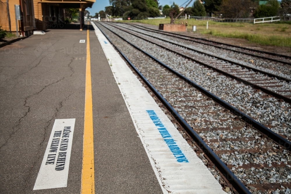 Signs and yellow line on the train station platform - Australian Stock Image